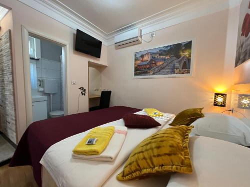 een slaapkamer met 2 bedden en handdoeken bij Hostel Dino in Mostar