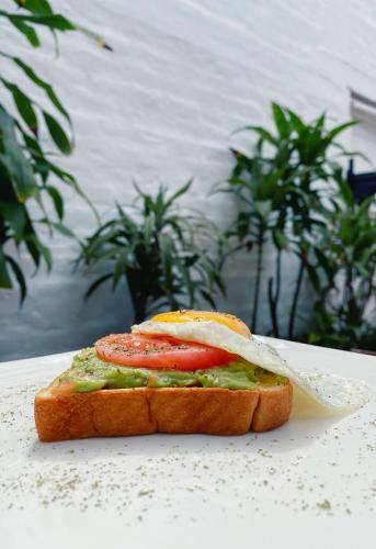 a sandwich with a tomato and avocado on a table at The Lot Boutique in Lima