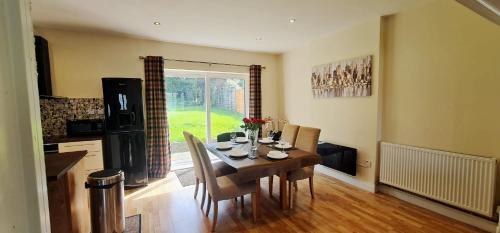 a kitchen and dining room with a table and chairs at Fairview Cottage Watford in Leavesden Green