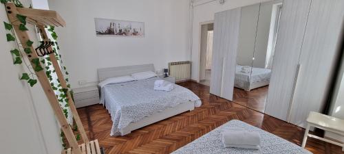 a small bedroom with two beds and a mirror at Appartamenti Fiore in Sanremo