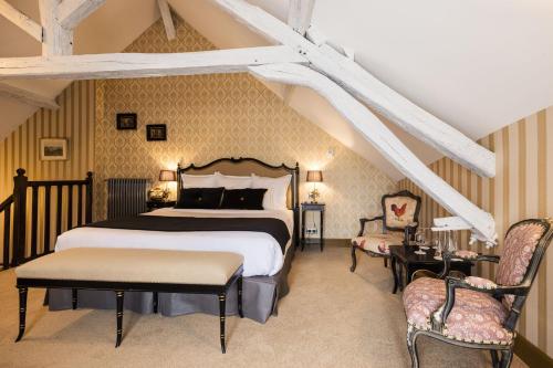 a bedroom with a large bed and two chairs at LE PETIT MANOIR in Sarlat-la-Canéda