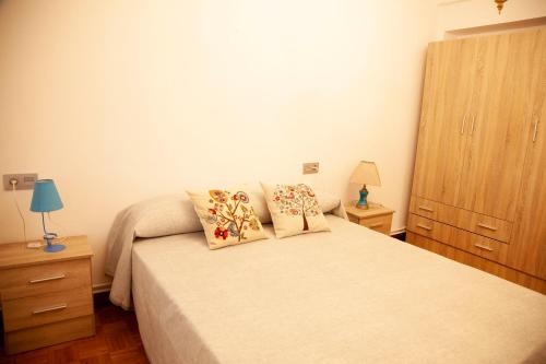una camera con un letto con due cuscini sopra di Pisito en los Campos al lado de la playa S.Lorenzo a Gijón