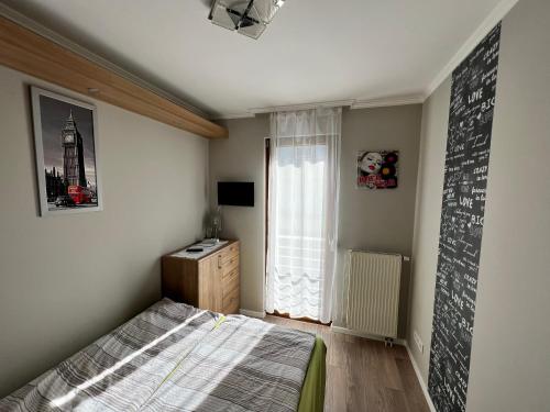 a bedroom with a bed and a chalkboard on the wall at Dorina Wellness Apartman in Siófok