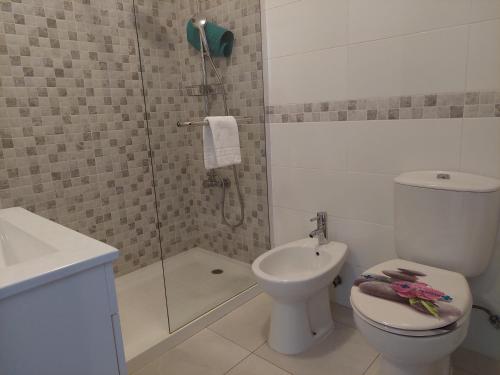 uma casa de banho com um chuveiro, um WC e um lavatório. em Alltravel Safira Apartment em Portimão