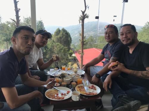 Un groupe d'hommes assis autour d'une table et mangeant de la nourriture dans l'établissement Mount Everest Hotel & Resort Nagarkot, à Nagarkot