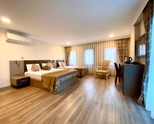 a hotel room with two beds and a desk at Caykent Suites Deluxe Hotel in Trabzon