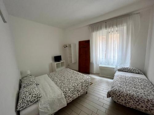 een slaapkamer met 2 bedden en een raam bij Il Guasco Rooms in Ancona