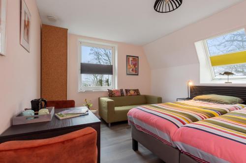 - une chambre avec un lit et un canapé dans l'établissement Lowlander BnB, à Heemskerk