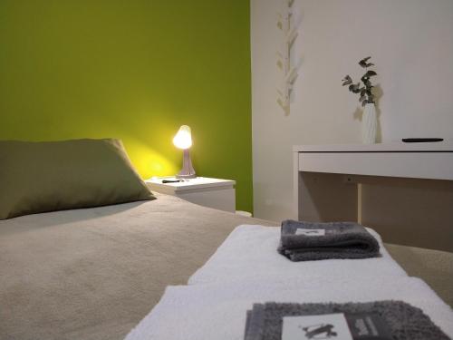 a bedroom with a bed with a green wall at PENSION132 in A Coruña