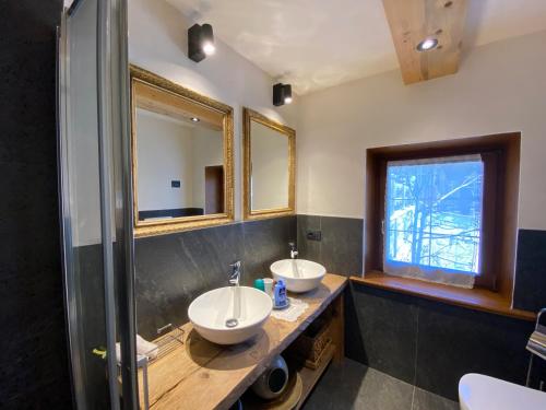 a bathroom with two sinks and a mirror at Mountain Chalet Milly in Livigno