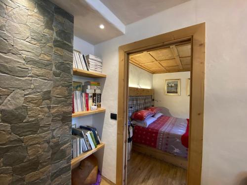 a bedroom with a bed and a stone wall at Mountain Chalet Milly in Livigno
