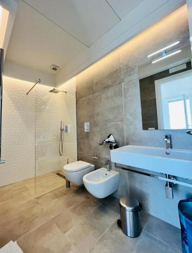 a bathroom with a tub and a toilet and a sink at Villa Maria Luxury Suites in Sperlonga