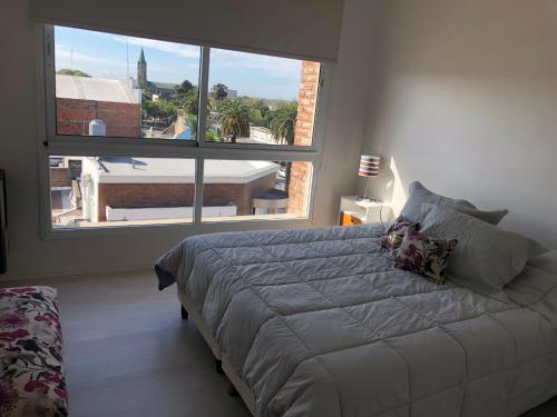 1 dormitorio con cama y ventana grande en Bizitza Ona Alojamiento Ramallo 3B en Ramallo