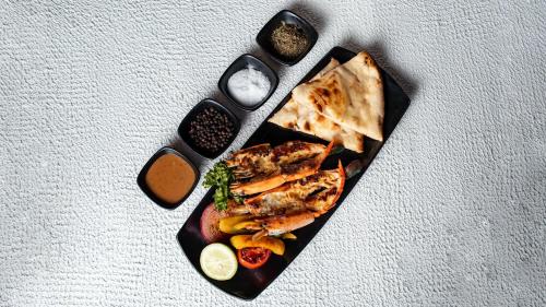 a black plate with food on a table at InterContinental Dhaka by IHG in Dhaka