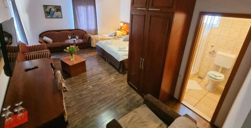 a small living room with a bed and a bathroom at Visovac Rooms in Skradin