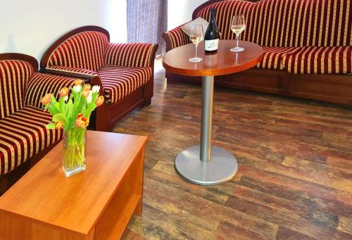 a room with couches and a table with two glasses of wine at Visovac Rooms in Skradin
