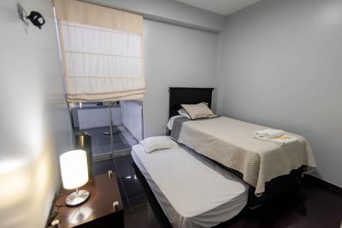 um pequeno quarto com duas camas e uma mesa em Miraflores Apartment em Lima