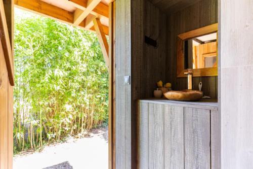 a door leading into a room with a bathroom with a window at Cabane perchee in Vert