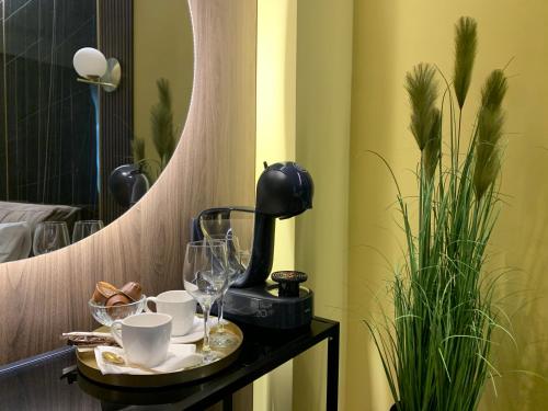 - un plateau avec des tasses et des verres sur une table avec un miroir dans l'établissement Luxury Sahara Noir Mamaia Nord, à Mamaia