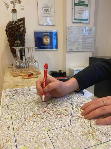 a person holding a red marker on a map at Hotel RossoVino Milano in Milan