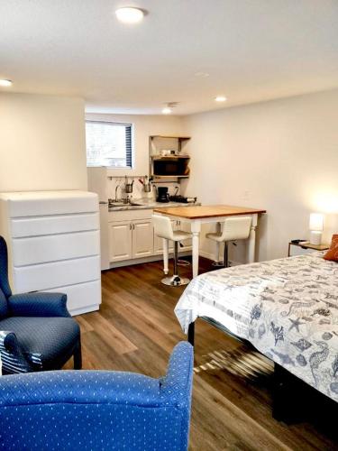 a bedroom with a bed and a table and a kitchen at Two Fully Equipped Apartments and a Studio 5 miles from the beach in St. Petersburg