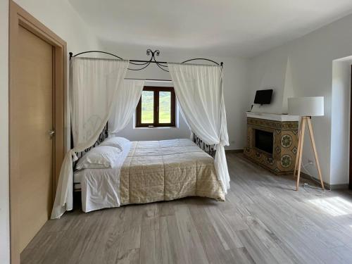 a bedroom with a canopy bed and a fireplace at Antico Borgo Buonanotte in San Mauro Castelverde