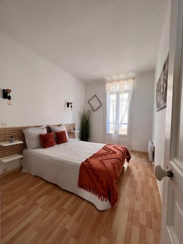 a white bedroom with a large bed and a window at Superbe maison de ville in Narbonne