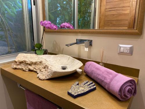 a bathroom counter with a sink and a purple towel at Casarte Boutique Hotel in Playa del Carmen