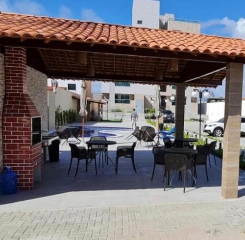 a patio with tables and chairs under a pavilion at Makambira Residence 201 in Porto De Galinhas