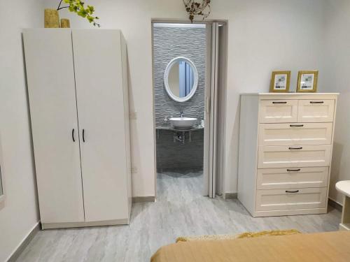 a bathroom with a white dresser and a mirror at Jasmin at Bayview in Pembroke