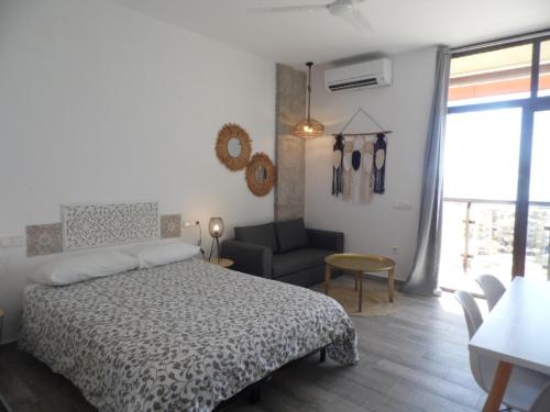 a bedroom with a bed and a couch and a chair at Puerto Marina in Benalmádena