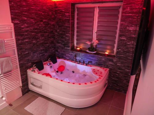 a bath tub in a bathroom with a window at Appartement - Jacuzzi - Pour deux in Besançon
