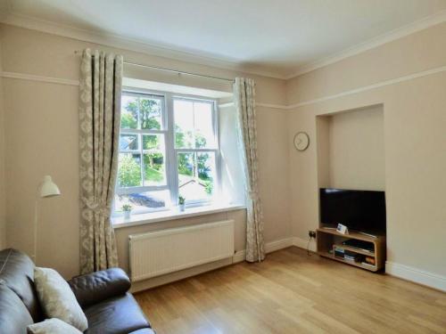 sala de estar con sofá y ventana en Great location, quiet yet 5 mins to Bowness centre with walks from the door and parking, en Bowness-on-Windermere