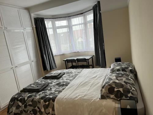 a bedroom with a large bed and a window at North West Lodge Guest House in London