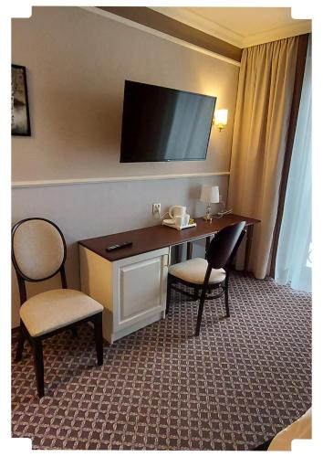 a hotel room with a desk and two chairs at Arkadia in Radziejów