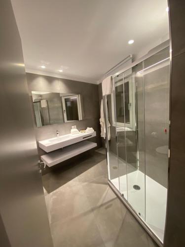 a bathroom with a sink and a glass shower at IL DUCA HOUSE e HOLIDAY PRESTIGE in Caccamo