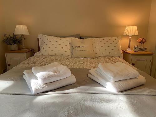 a bed with two folded towels on top of it at Bramble cottage at Waingrove Farm in Louth