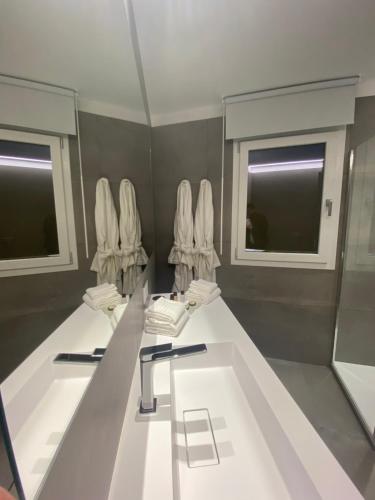a bathroom with two sinks and mirrors and windows at IL DUCA HOUSE e HOLIDAY PRESTIGE in Caccamo