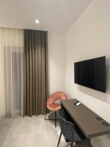 a room with a table and a chair and a television at IL DUCA HOUSE e HOLIDAY PRESTIGE in Caccamo