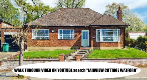 a house with a sign that reads walk through video on your youtube search function committee at Fairview Cottage Watford in Leavesden Green