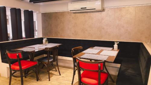 a dining room with two tables and red chairs at Verde Vale Hotel in Videira