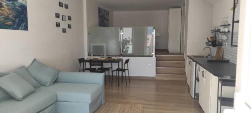 a living room with a couch and a kitchen at A Lobeira in Corcubión