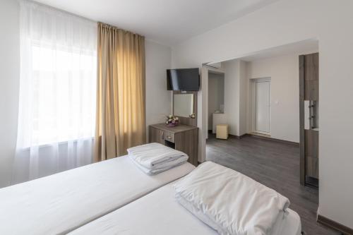 a hotel room with two beds and a flat screen tv at Мотел "Релакс" Motel "Relax", Балчик, in Balchik