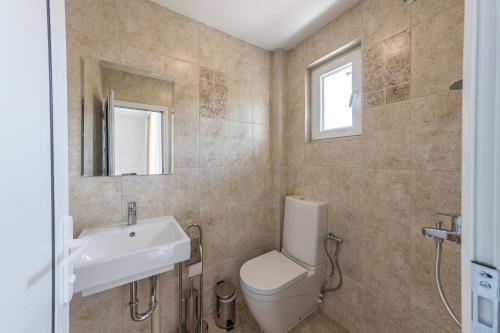 bagno con servizi igienici, lavandino e specchio di Мотел "Релакс" Motel "Relax", Балчик, a Balchik
