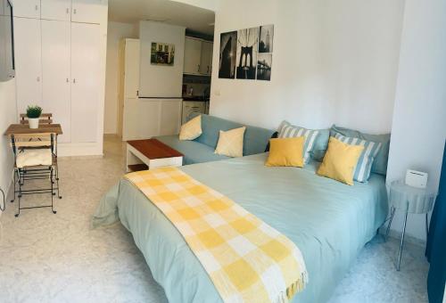 a bedroom with a large blue bed with yellow pillows at ACUARIO 22 in Benalmádena