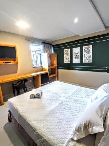 a bedroom with a large bed and a desk at Vila Aju - Pousada Temática in Aracaju