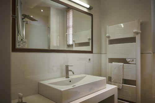 a white bathroom with a sink and a mirror at Chateau de Creissels in Creissels
