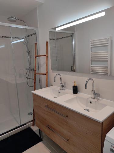 łazienka z 2 umywalkami i prysznicem w obiekcie Ty gwenn w mieście Cancale
