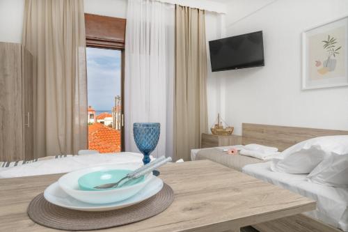 um quarto de hotel com uma mesa com um prato em SAND rooms to let em Nea Roda