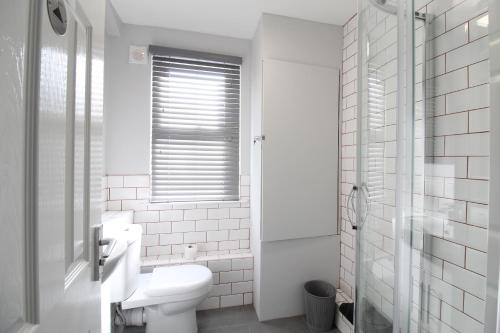 a white bathroom with a toilet and a window at Anfield house in Liverpool